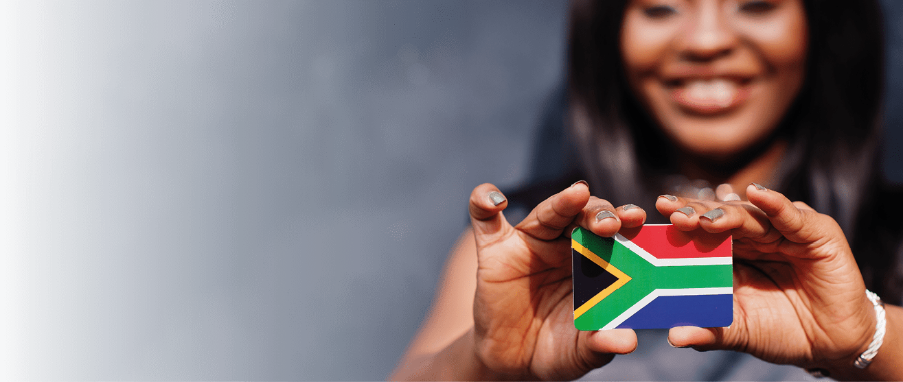 African woman hold small South Africa flag in hands.
