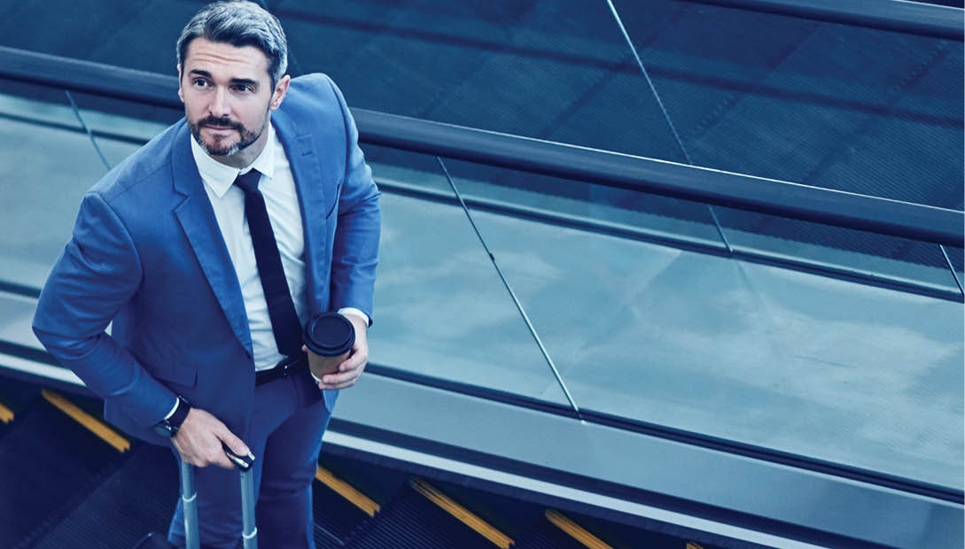Shot of a mature businessman traveling on an escalator in an airport